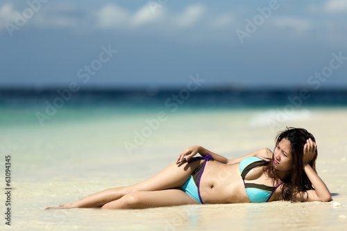 Filipina woman lying on sand