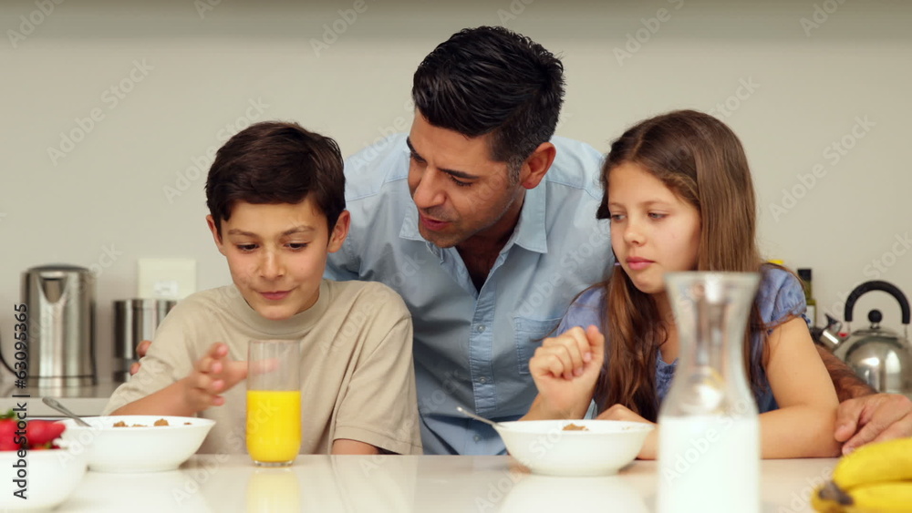 Father chatting with his children having breakfast Father chatting with his children having breakfast