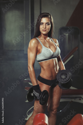 Woman with dumbbells in gym
