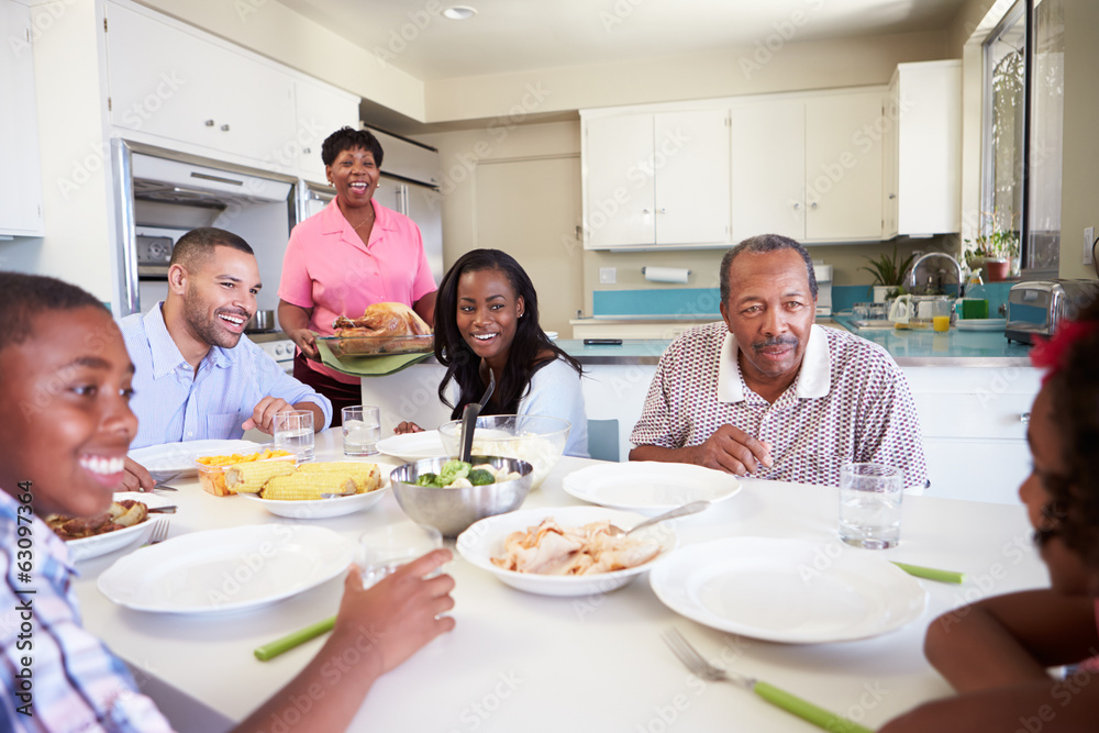 Multi-Generation Family Sitting Around Table Eating Meal Multi-Generation Family Sitting Around Table Eating Meal