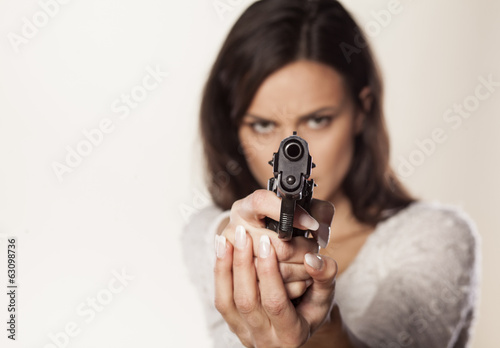 angry girl aiming a gun at you