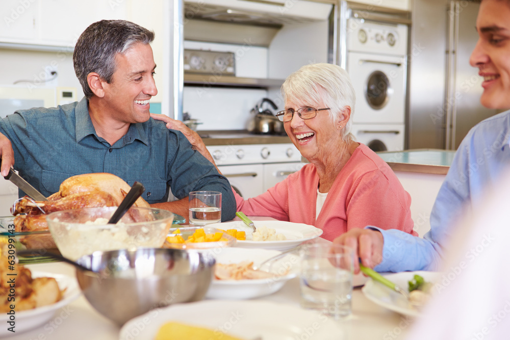 Multi-Generation Family Sitting Around Table Eating Meal Multi-Generation Family Sitting Around Table Eating Meal