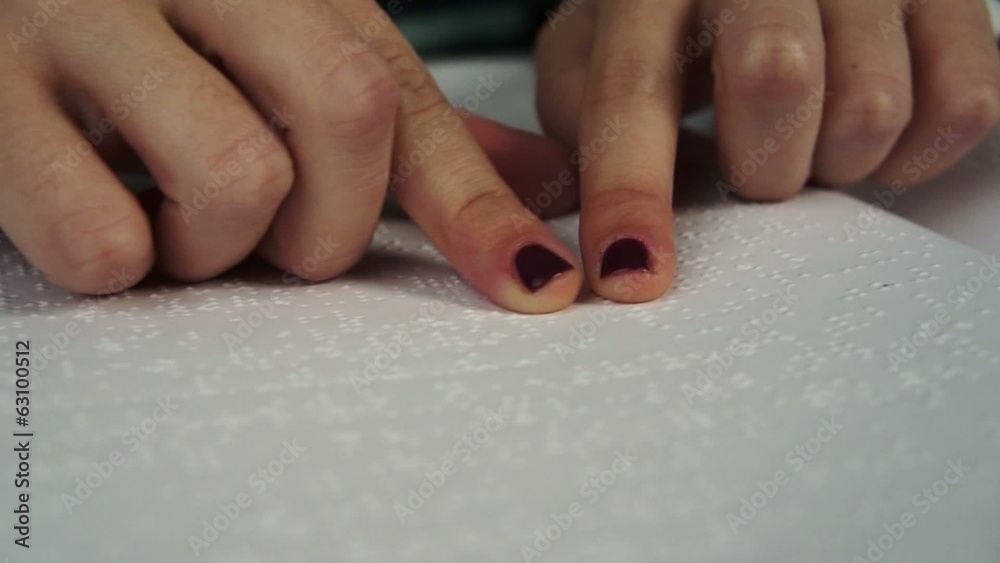 Blind woman reading text in braille language Blind woman reading text in braille language