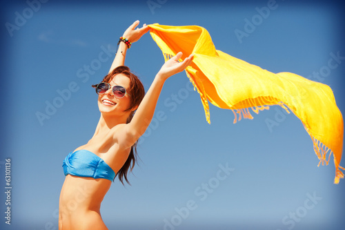 happy woman with yellow sarong on the beach