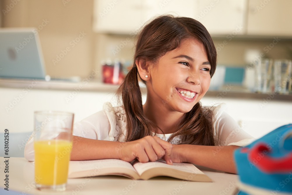 Hispanic Girl With Reading Homework At Table Hispanic Girl With Reading Homework At Table