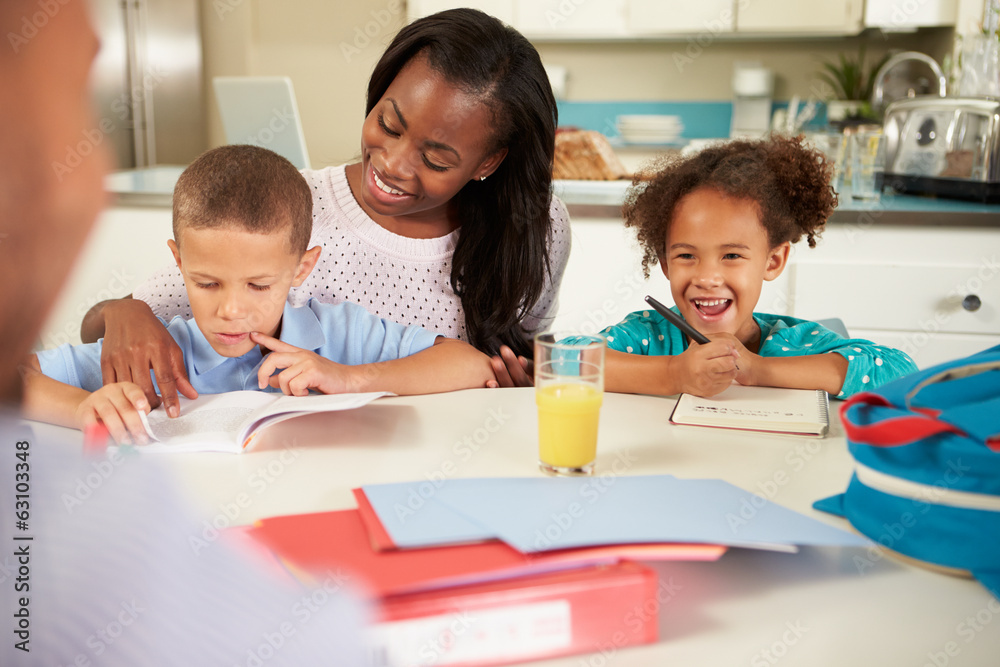 Mother Helping Children With Homework At Table Mother Helping Children With Homework At Table