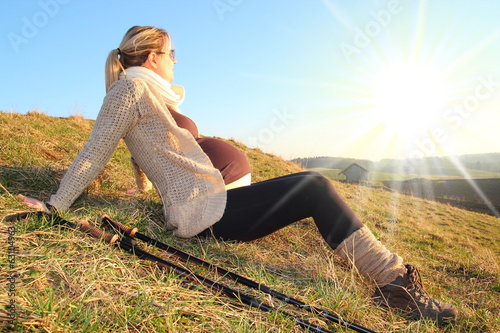 Schwangere Frau beim Wandern ruht sich aus 2 photo