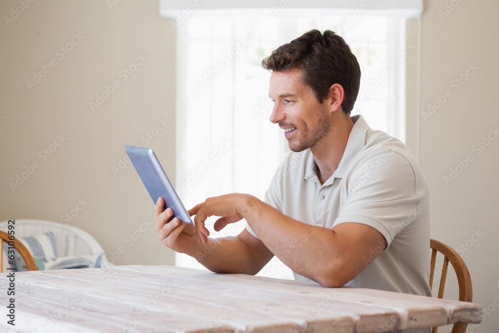 Young man using digital tablet at table Young man using digital tablet at table