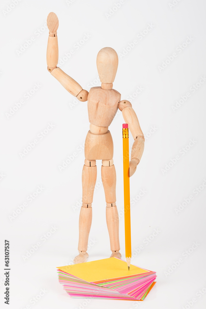 Small wood mannequin stand writing with colour pencil isolated o Small wood mannequin stand writing with colour pencil isolated o