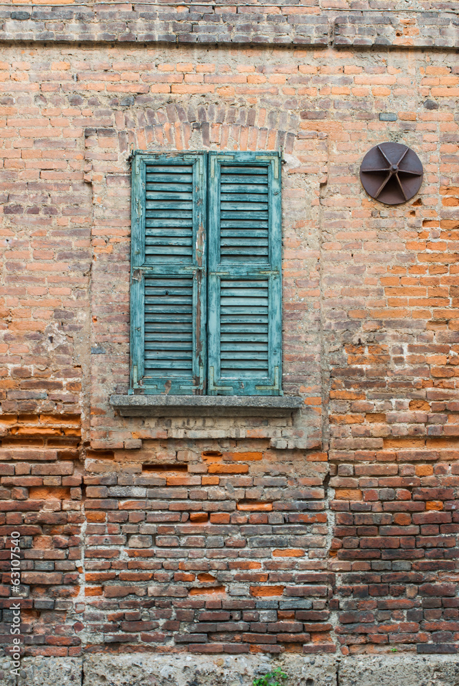 Facciata muro di mattoni e persiane, vecchia casa Facciata muro di mattoni e persiane, vecchia casa