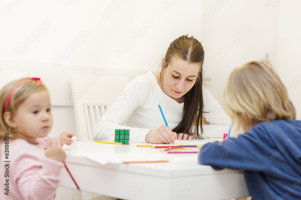 Mother with two children drawing with colorful crayons Mother with two children drawing with colorful crayons