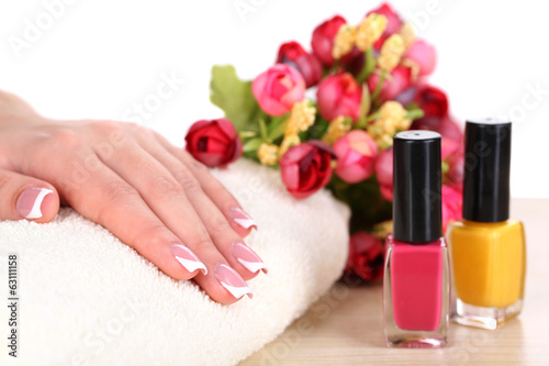 Beautiful woman hands with french manicure and flowers