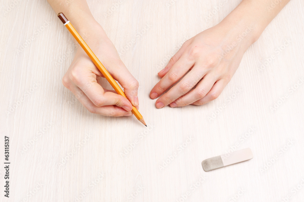 Human hands with pencil and erase rubber