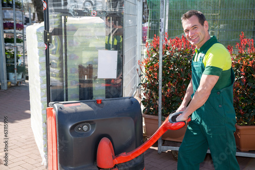 Worker with forklift in warehouse or storehouse