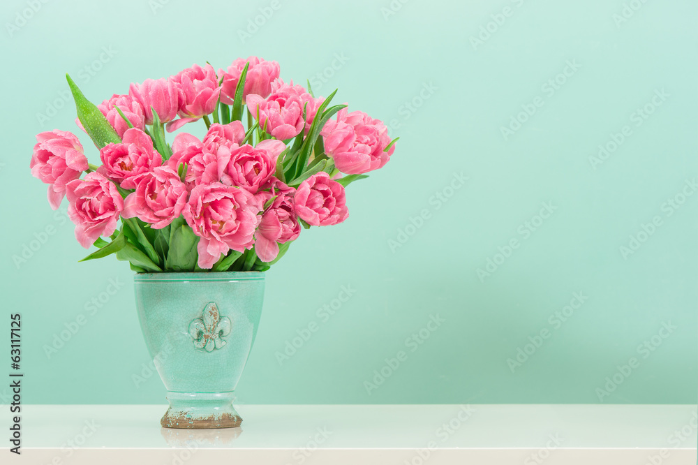 pastel pink tulip flowers over turquoise