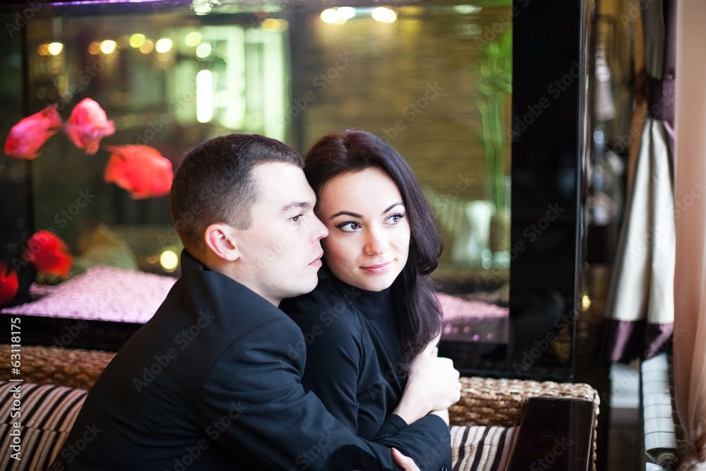 beautiful young couple in love cuddling in restaurant