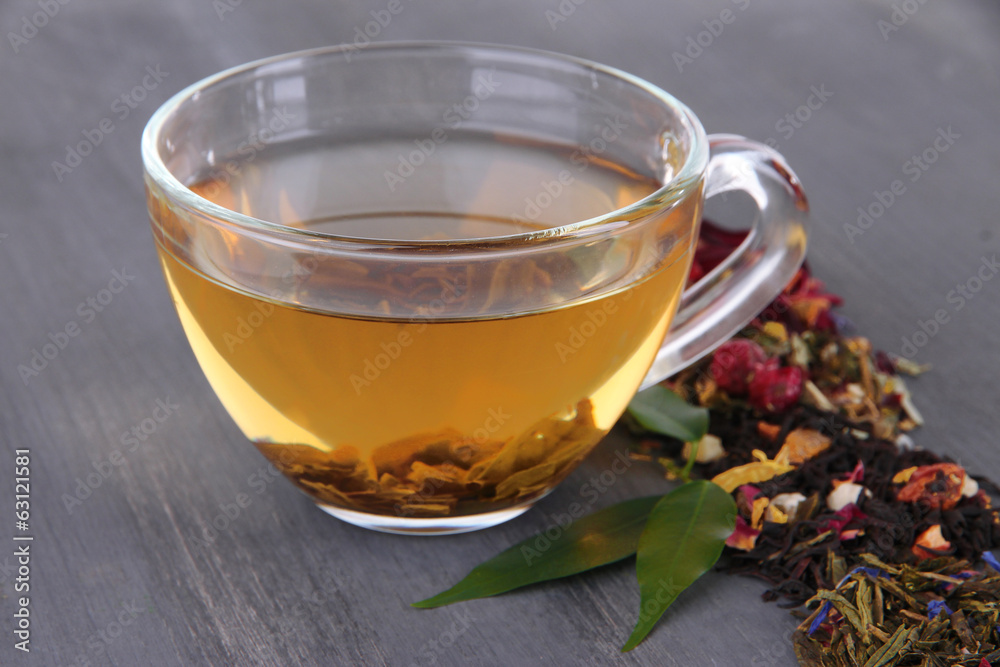 Cup of tea with aromatic dry tea on wooden background Cup of tea with aromatic dry tea on wooden background