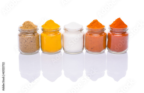 Salt and various spices over white background