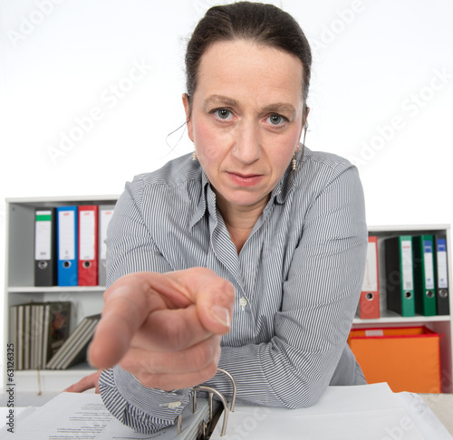 angry business woman is pointing in to the camera photo