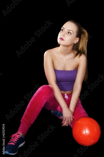 Woman with soccer ball isolated on black background