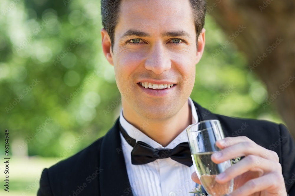Young groom drinking champagne in garden Young groom drinking champagne in garden
