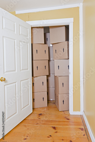 An open door reveals stacked cardboard boxes blocking the doorway.