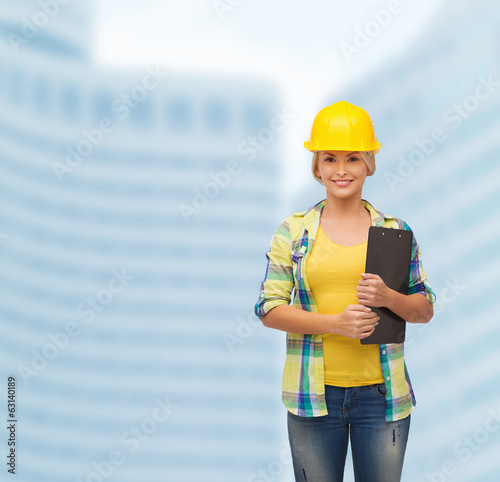 smiling woman in helmet with clipboard photo