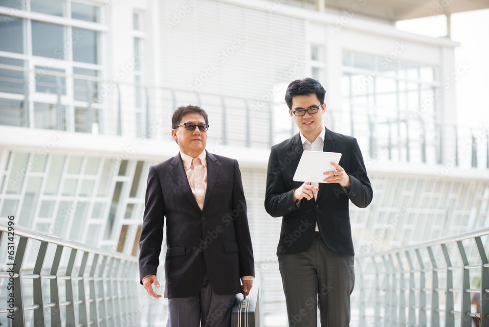 asian business male chatting on tablet asian business male chatting on tablet
