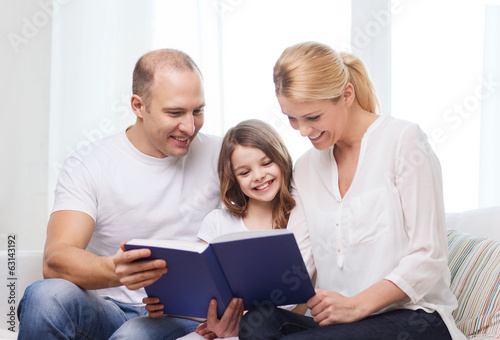 smiling parents and little girl with at home