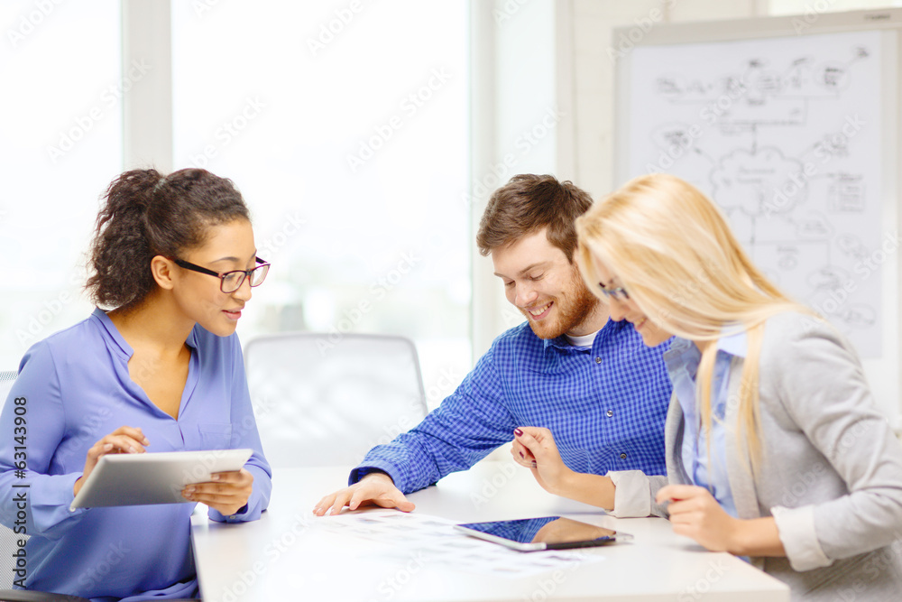 smiling team with table pc and papers working smiling team with table pc and papers working