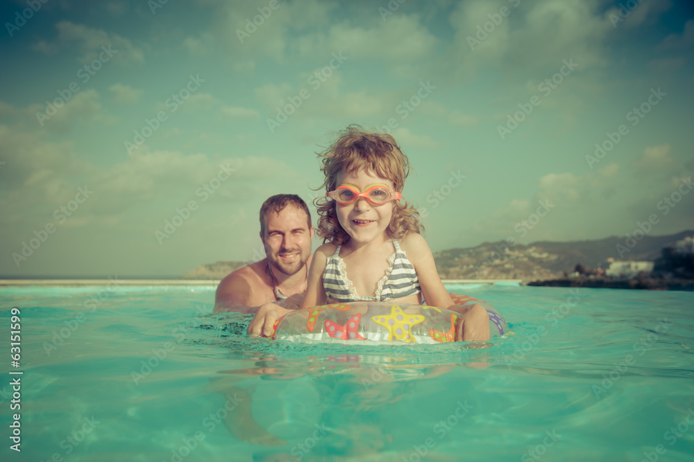 Happy child with father in swimming pool