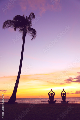 Yoga meditation - silhouettes of people at sunset