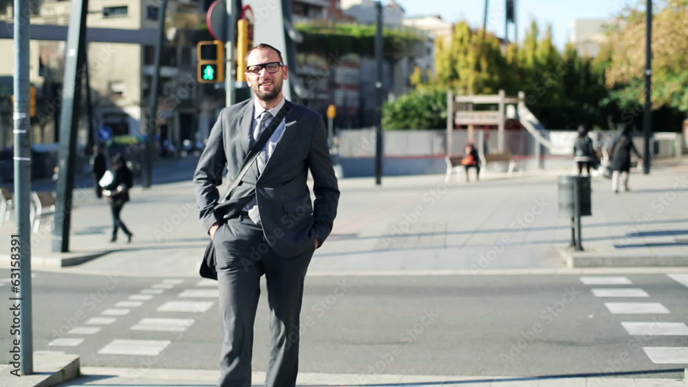 Businessman crossing street and smiling to camera Businessman crossing street and smiling to camera