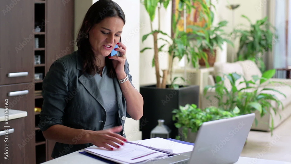Happy businesswoman talking on cellphone in office, steadycam sh Happy businesswoman talking on cellphone in office, steadycam sh