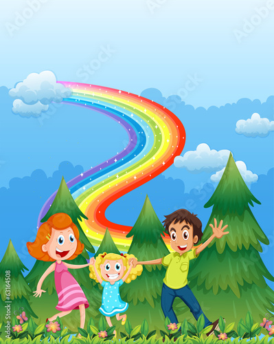 A happy family near the pine trees with a rainbow in the sky