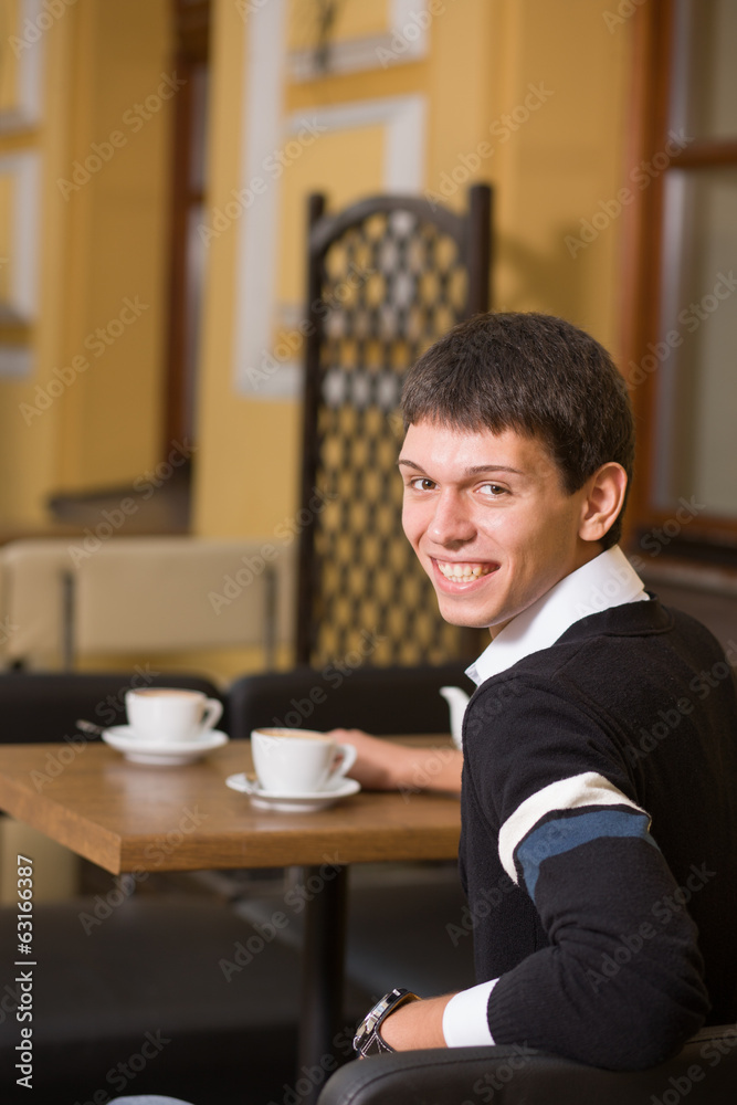 Young man across table with cup of coffee