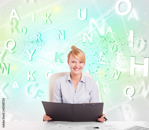 Business woman at desk with green word cloud