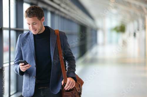 Man on smart phone - young business man in airport