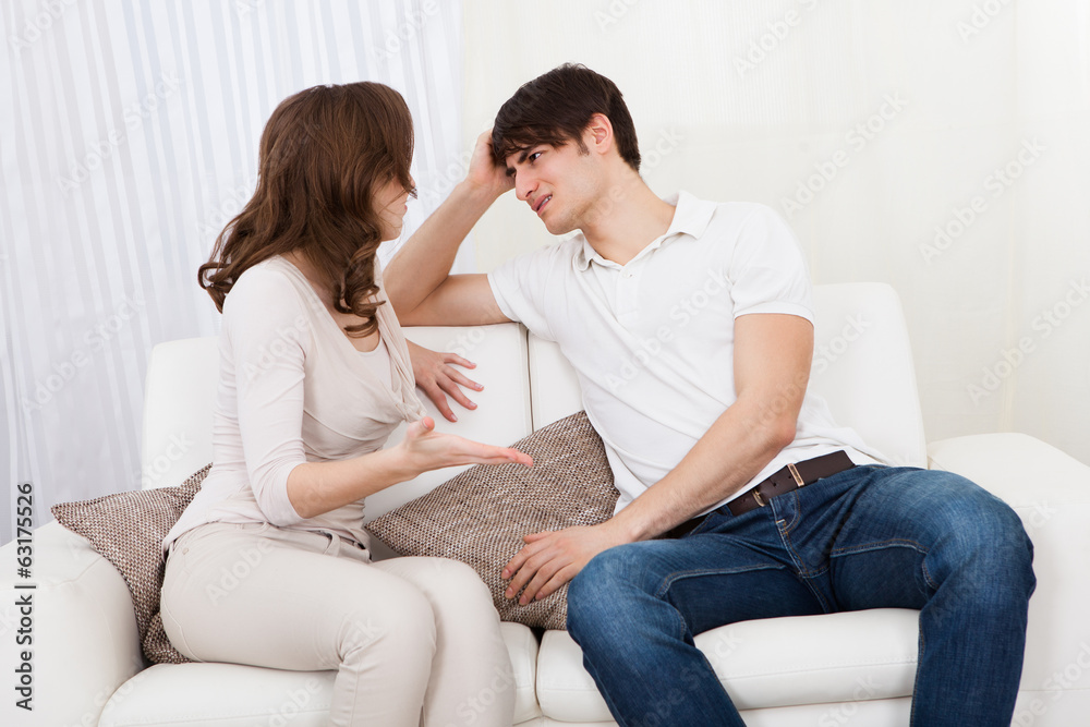 Portrait of couple sitting on sofa having quarrel