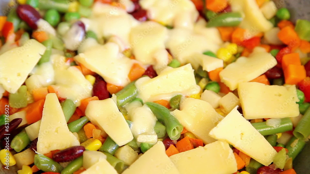 Time lapse of melting cheese on vegetable mix Time lapse of melting cheese on vegetable mix