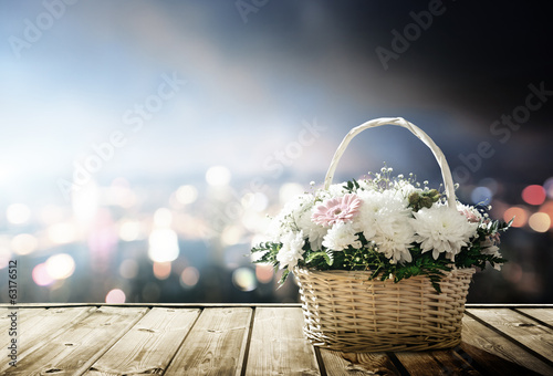 flowers in basket and lights of night city