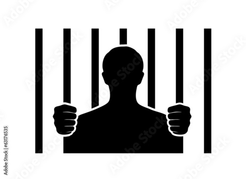 silhouette of a man behind bars