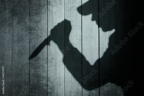 Human Silhouette with Knife in shadow on wooden background, XXXL photo