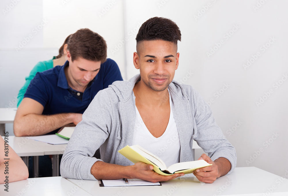 Male University Student Writing At Desk Male University Student Writing At Desk