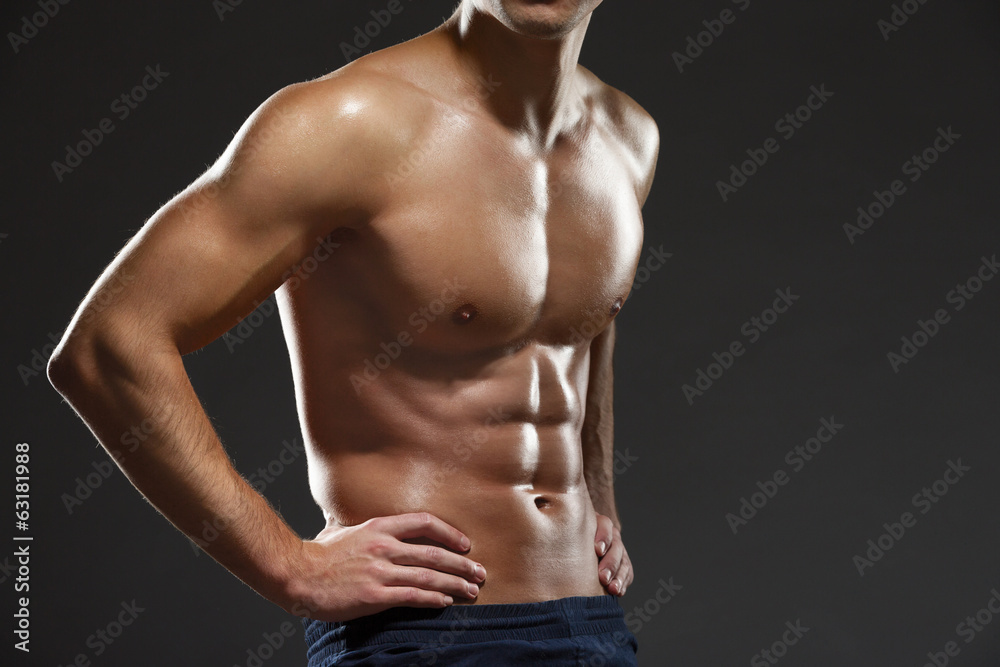 Close up of naked male's torso, isolated on black