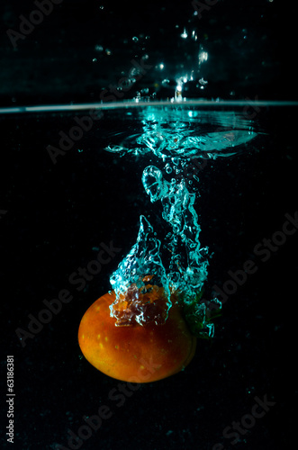 Tomato water splash on black background