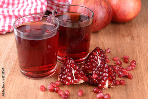 Ripe pomegranates with juice on table close-up