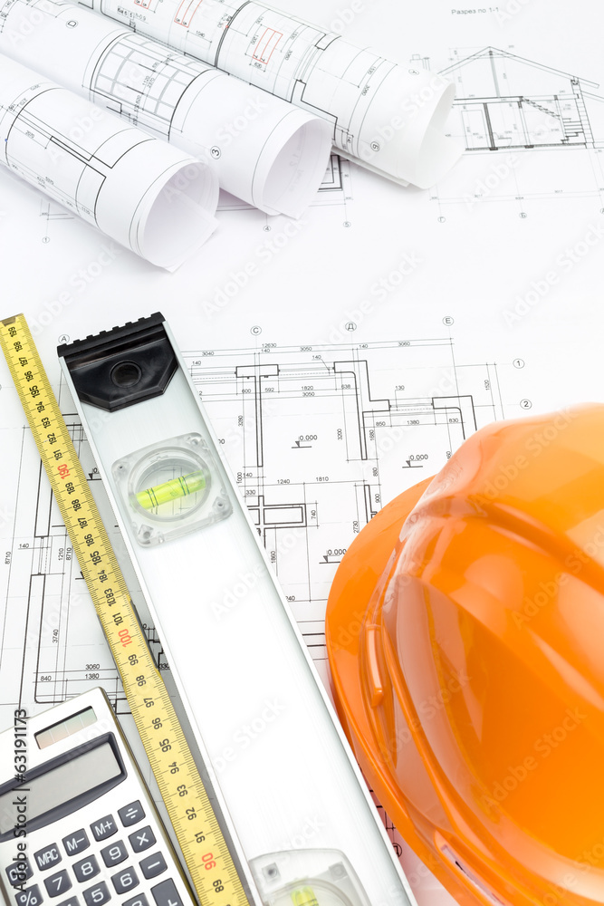 Orange safety helmet and rolled project drawings Orange safety helmet and rolled project drawings