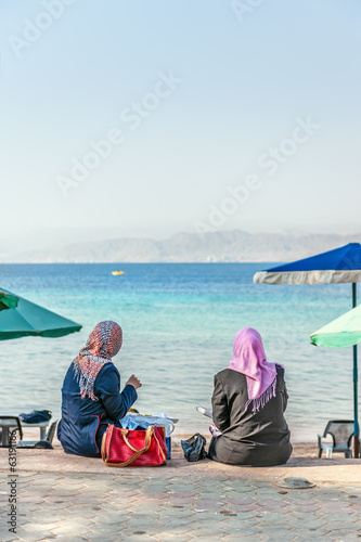 Two arab women lunch at seaside