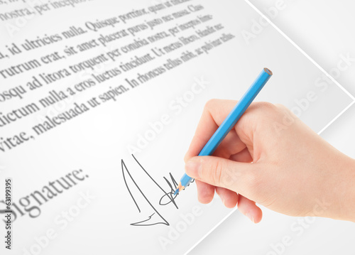 Hand writing personal signature on a paper form